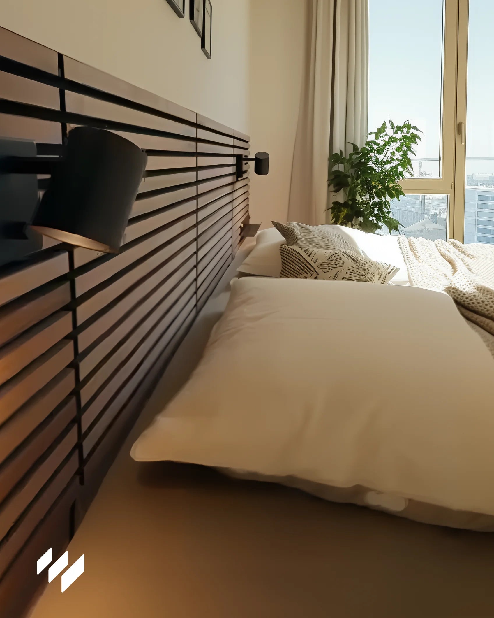 Detalle lateral de un cabecero con listones horizontales en Roble Ahumado, bañado por luz natural junto a una ventana.