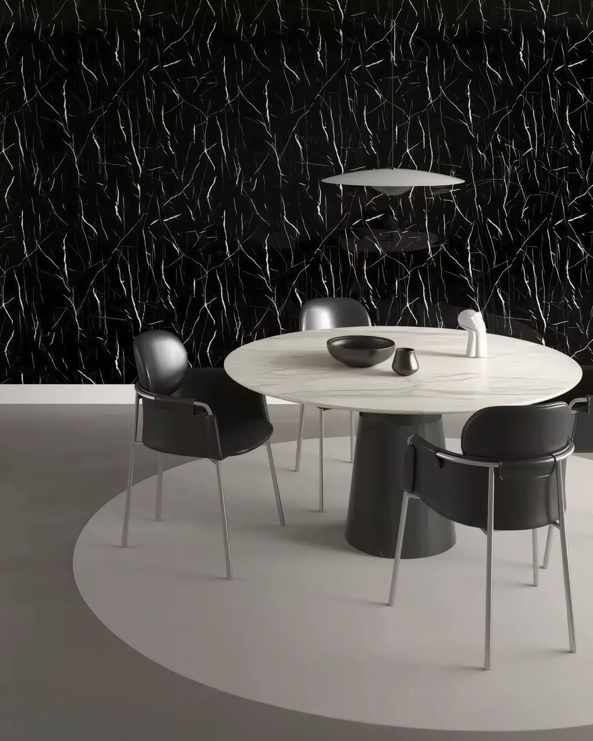 Panel WPC Alto Brillo efecto Mármol Negro Marquina en pared de comedor moderno con mesa redonda de mármol blanco y sillas negras, aportando contraste y estilo minimalista.