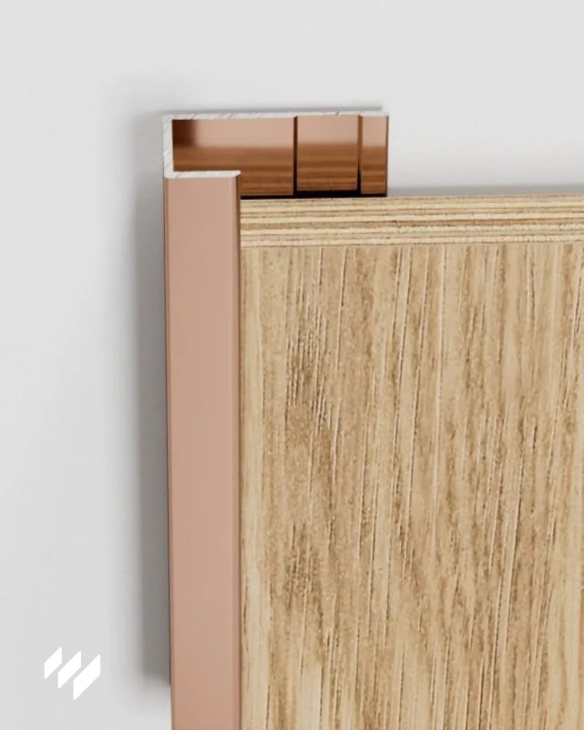 Detalle del Perfil de remate en U de aluminio oro rosa brillante instalado en panel decorativo de revestimientos pared