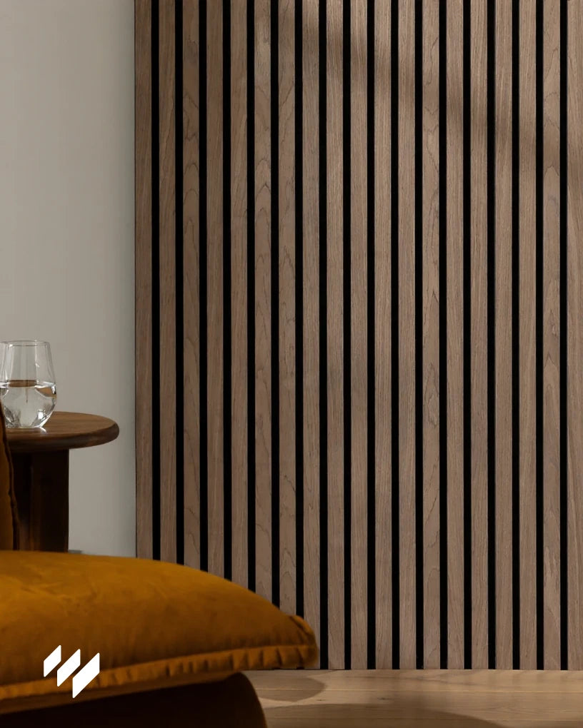 Primer plano de un panel acústico de listones color Nogal Natural de Revestimientos Pared, con textura de madera cálida y sombras suaves que realzan su profundidad estética.
