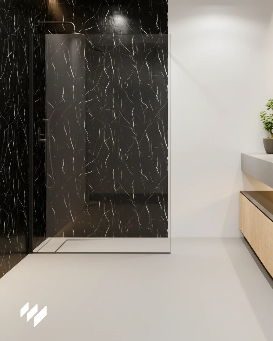 Zona de ducha con pared revestida en Panel WPC Alto Brillo efecto Mármol Negro Marquina de Revestimientos Pared, destacando su brillo profundo y vetas blancas en un baño minimalista.