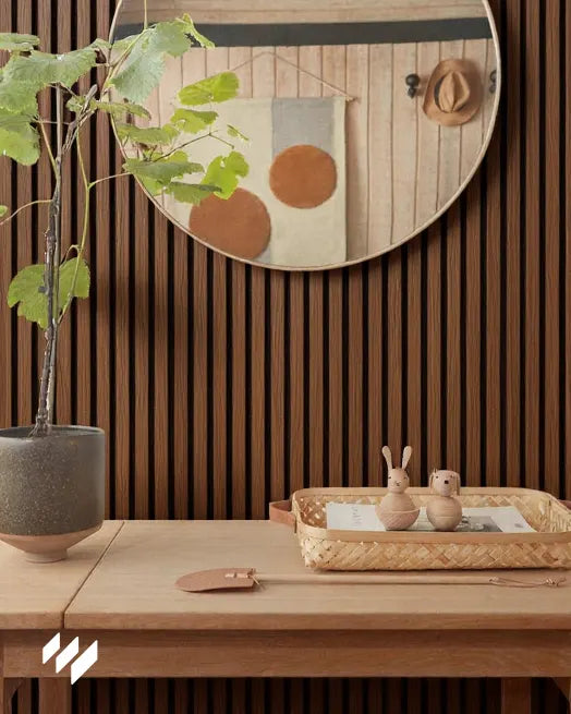 Panel decorativo Roble Ahumado de Revestimientos Pared colocado en zona de entrada con consola de madera clara y espejo circular decorativo.