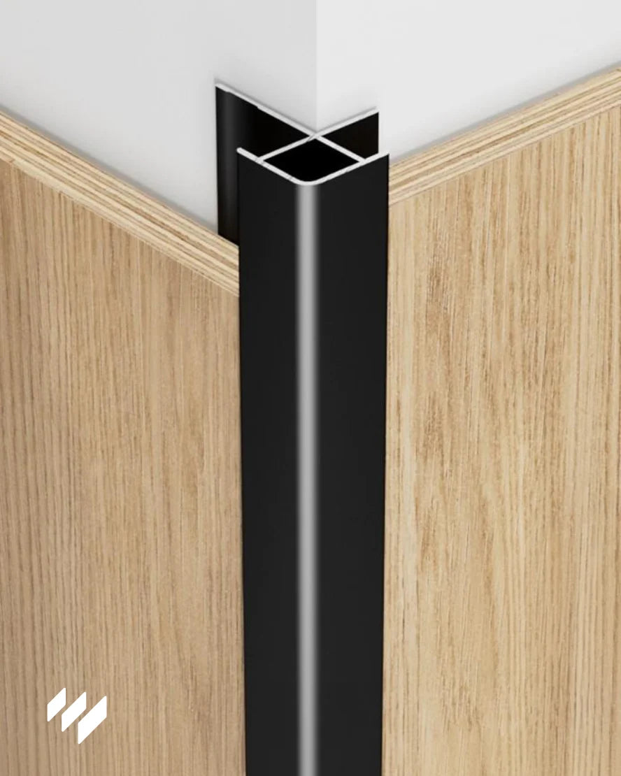 Perfil de Esquina Exterior Cuadrada de Aluminio Negro Mate instalado en una esquina con paneles decorativos de madera, imagen de revestimientos pared.
