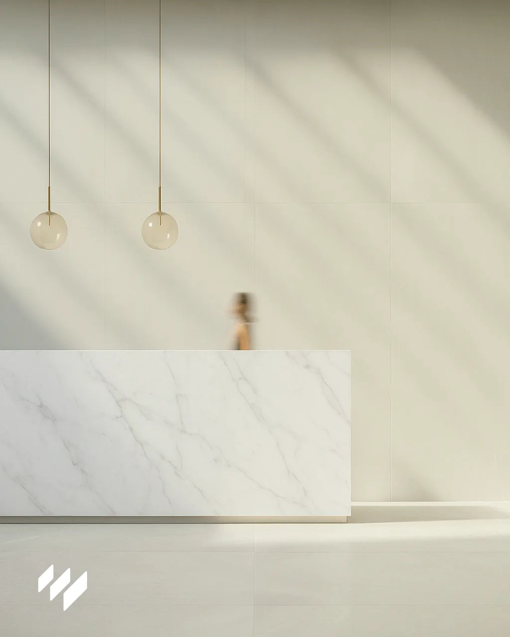 Mostrador minimalista revestido en panel SPC efecto mármol blanco Carrara en un lobby iluminado con lámparas esféricas colgantes.