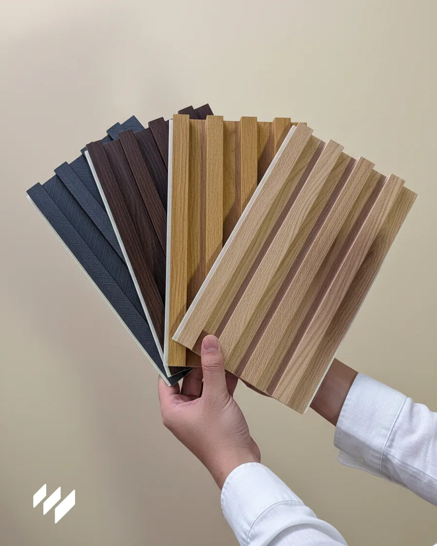 Muestras de paneles decorativos de listones WPC de la colección Linnea sostenidas con las manos, disponibles en varios tonos madera, de Revestimientos Pared.