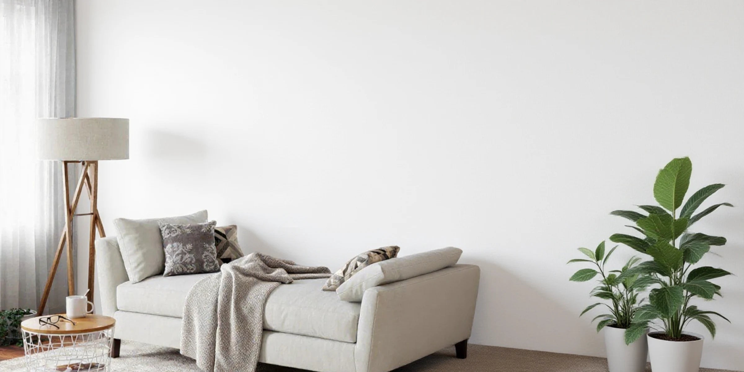 Pared blanca lisa antes de la instalación del panel acústico autoadhesivo de listones en color Roble Natural, en un salón moderno y luminoso. PC view.