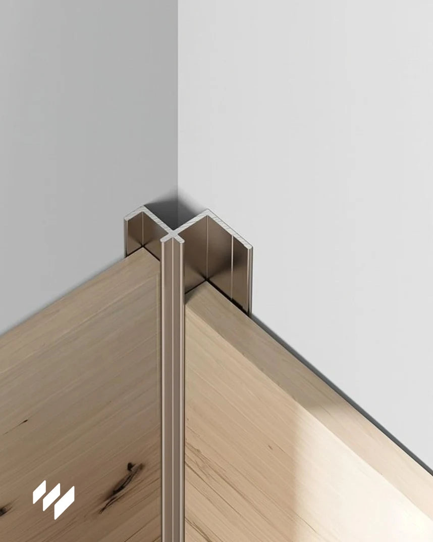 Perfil de esquina interior de aluminio en color oro rosa brillante instalado en un ángulo interior sobre paneles decorativos, aplicación real de revestimientos pared