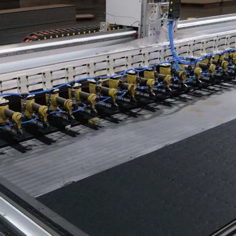 Máquina industrial fijando fibras de poliéster y MDF en los slatwall acústicos de Revestimientos Pared durante el proceso de fabricación.