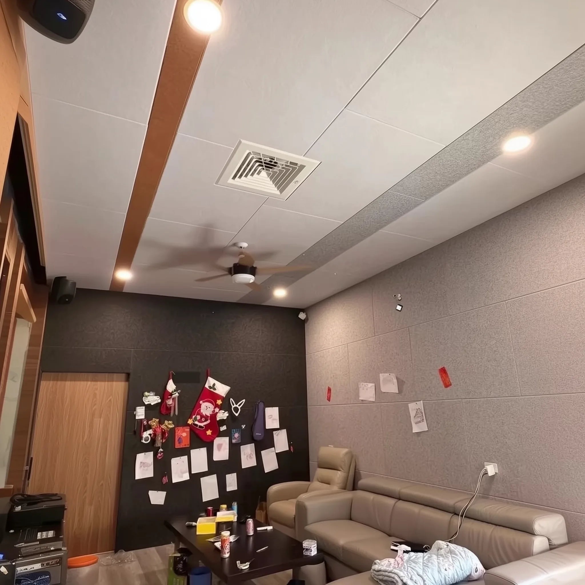 Sala moderna con paneles acústicos autoadhesivos de poliéster instalados en el techo y paredes. El ambiente muestra una notable mejora en la absorción de sonido, ideal para reducir el ruido de vecinos de pisos superiores.