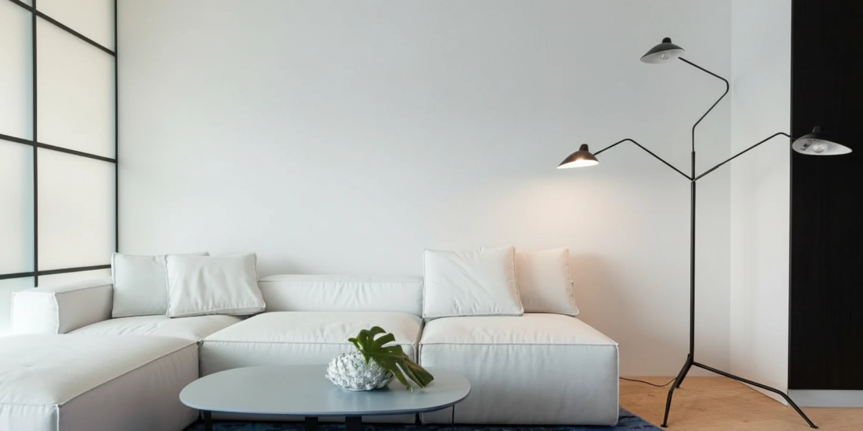 Salón contemporáneo en Barcelona con sofá blanco y pared lisa antes de instalar los paneles decorativos de Revestimientos Pared.