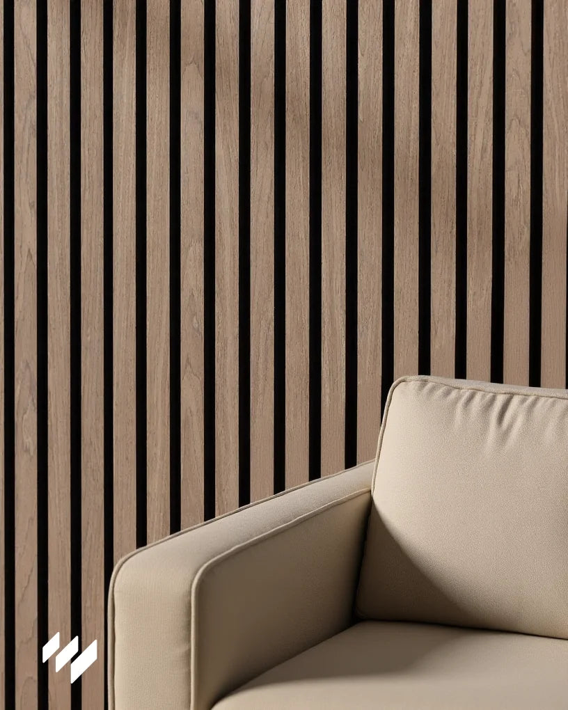 Panel acústico de listones Nogal Natural de Revestimientos Pared combinado con un sofá beige claro, destacando un diseño sereno y armonioso en interiores contemporáneos.