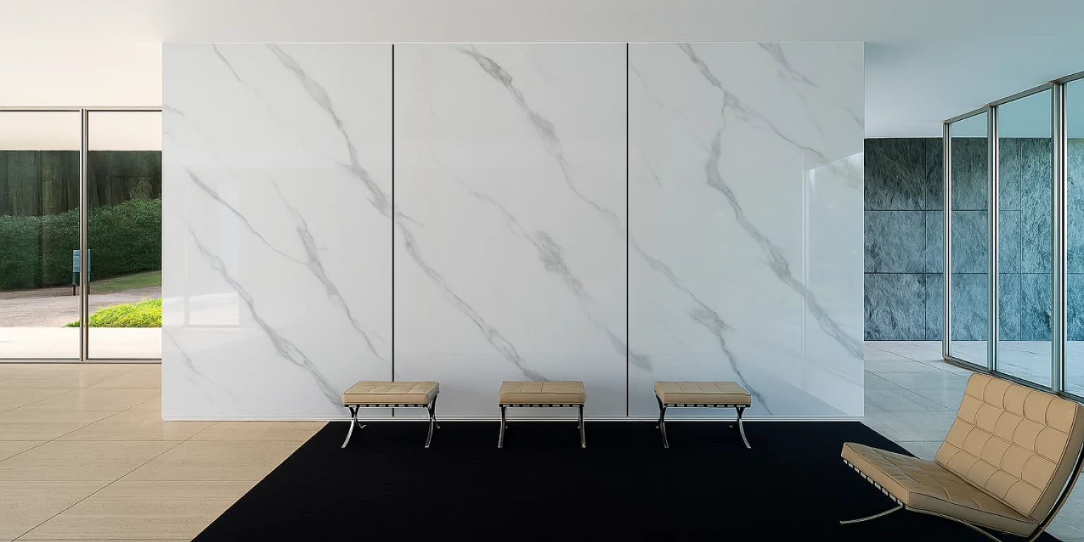 Pared transformada con paneles WPC alto brillo efecto mármol Calacatta Blanco, creando un ambiente sofisticado y contemporáneo en el espacio interior.