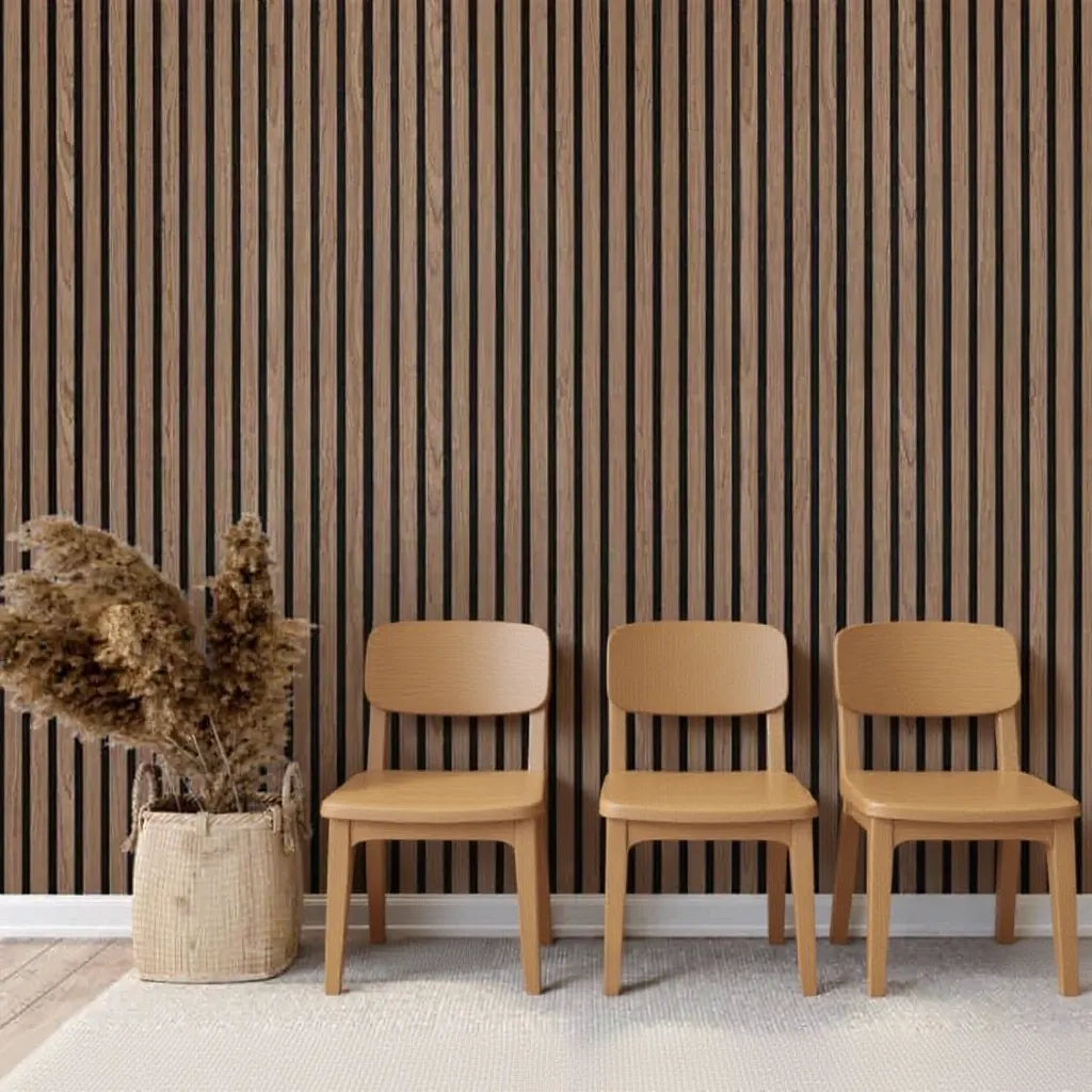 Instalación de panel acústico de listones Nogal Natural de Revestimientos Pared detrás de tres sillas de madera clara, ideal para espacios de recepción modernos y confortables.