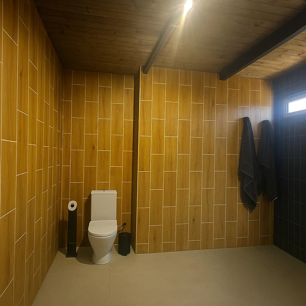 Baño moderno con paredes revestidas con paneles SPC efecto madera cerámica en patrón vertical escalonado, combinando con techo de madera y diseño minimalista.