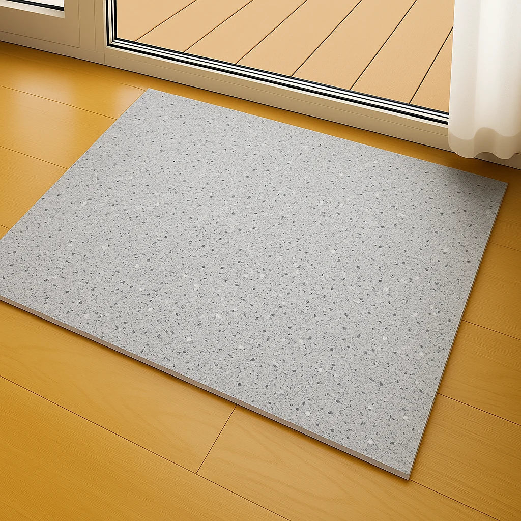 Panel SPC effecto terrazo colocado en el suelo junto a una ventana para ventilación natural y disipación del olor antes de la instalación.