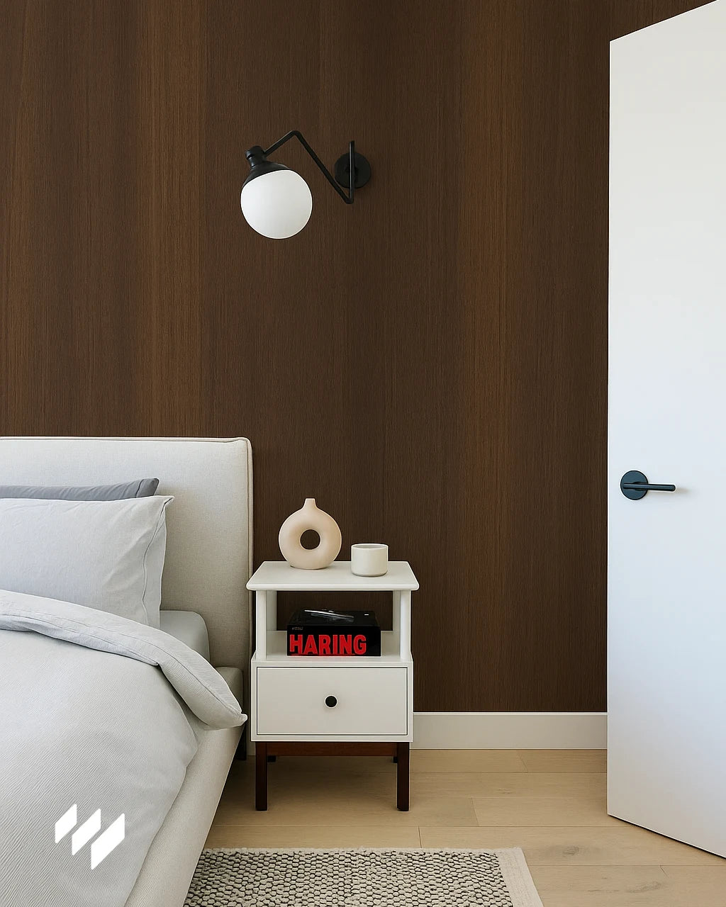Dormitorio minimalista con pared revestida en Roble Nocturno, destacando la mesita blanca y la lámpara de pared moderna.