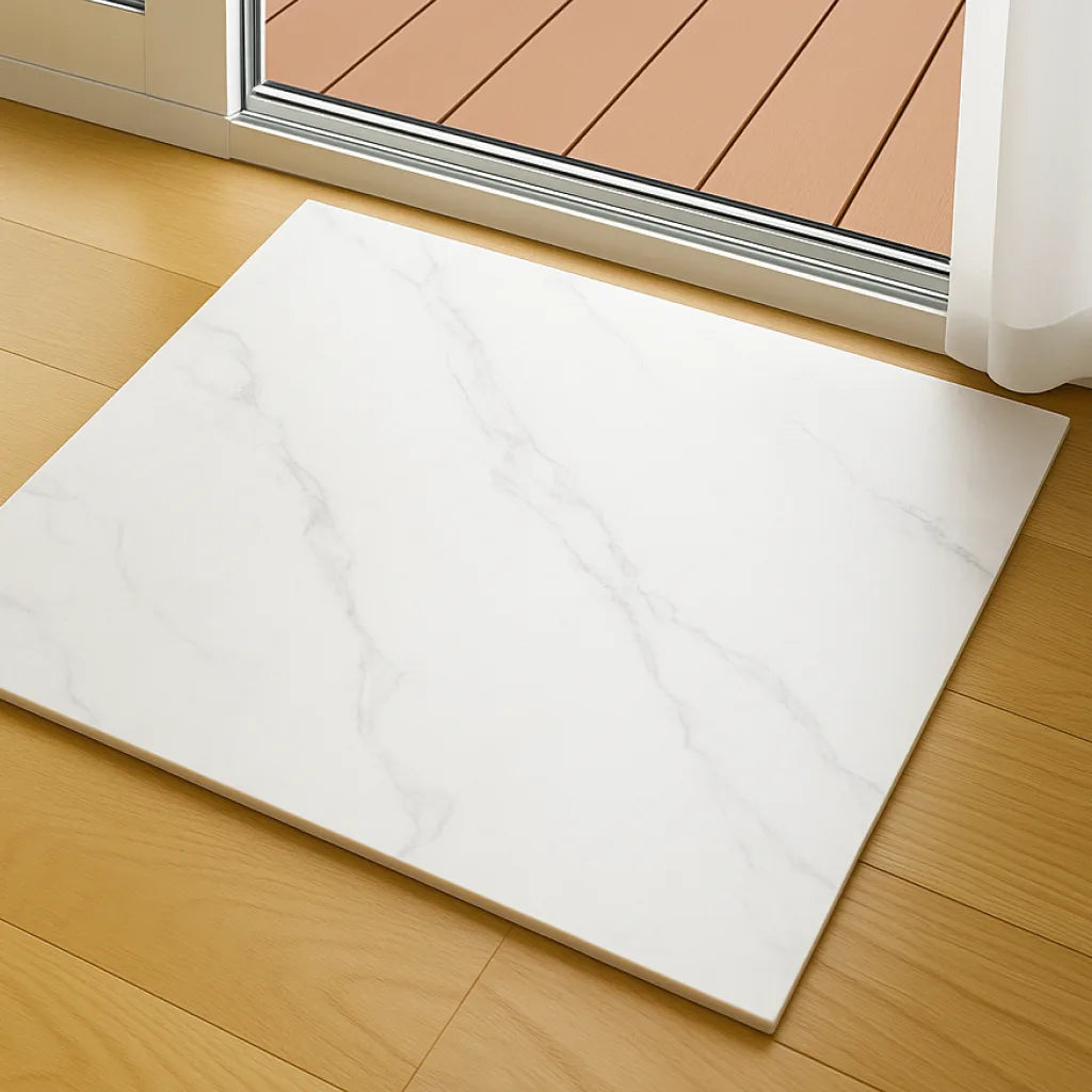 Panel de revestimiento SPC efecto mármol blanco colocado junto a una puerta de terraza.