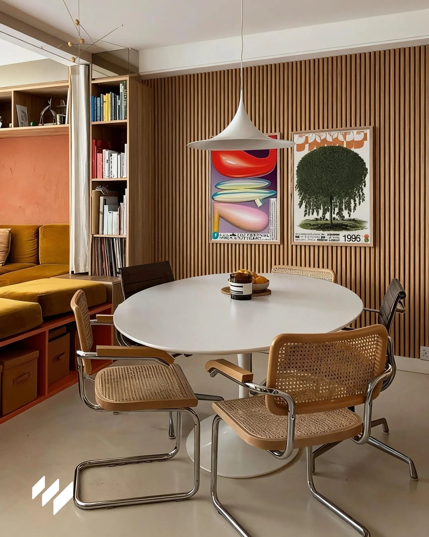 Pared de listones WPC Roble Miel en un comedor moderno con mesa redonda y sillas de mimbre en Madrid.