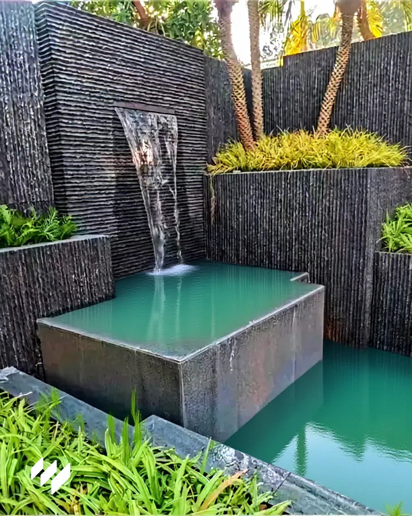 Fuente de jardín decorada con Revestimiento de pared efecto piedra acanalada negro de Revestimientos Pared, integrando diseño natural y elegante en espacios exteriores.