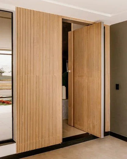 Paneles decorativos de listones WPC Roble Miel integrados en una puerta oculta en un salón contemporáneo de Alicante.