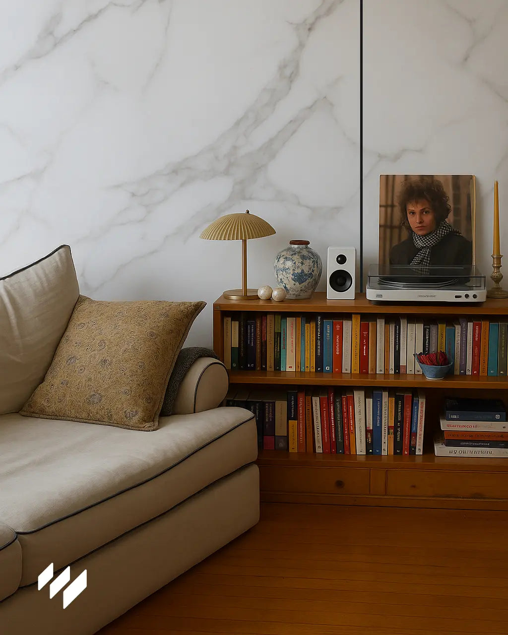 Espacio de lectura acogedor con sofá claro y paneles WPC Calacatta Blanco de Revestimientos Pared instalados en la pared del fondo.