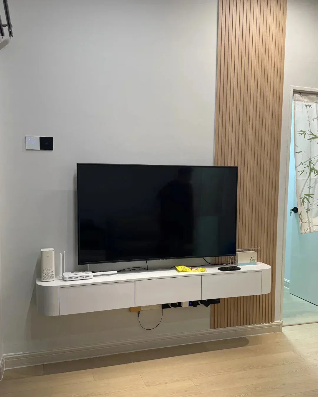 Antes y después: pared de TV con listones y mueble flotante en un piso antiguo de Barcelona