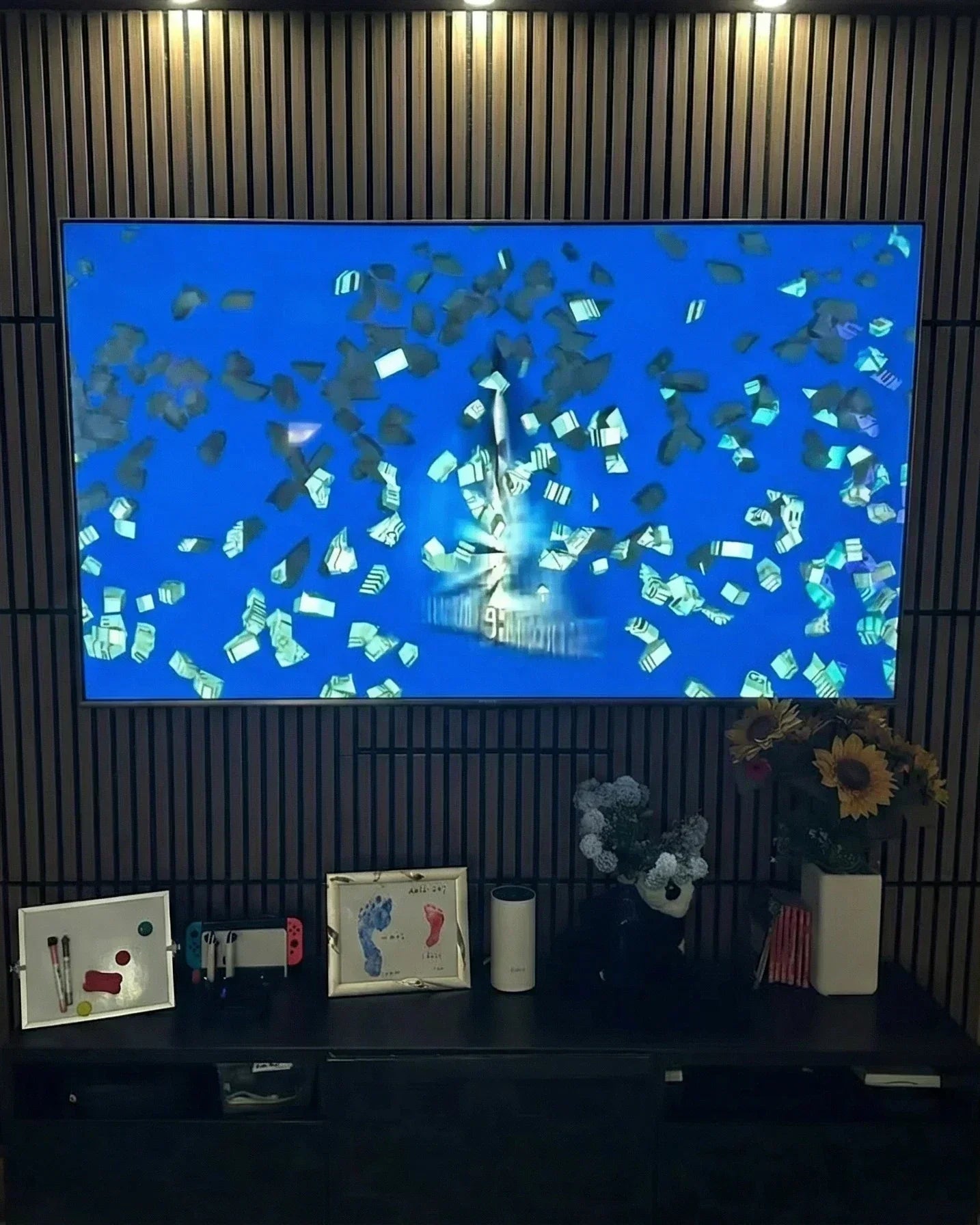 Autoadhesivo (sin obras): pared de TV con paneles de listones cuadrados en una tarde