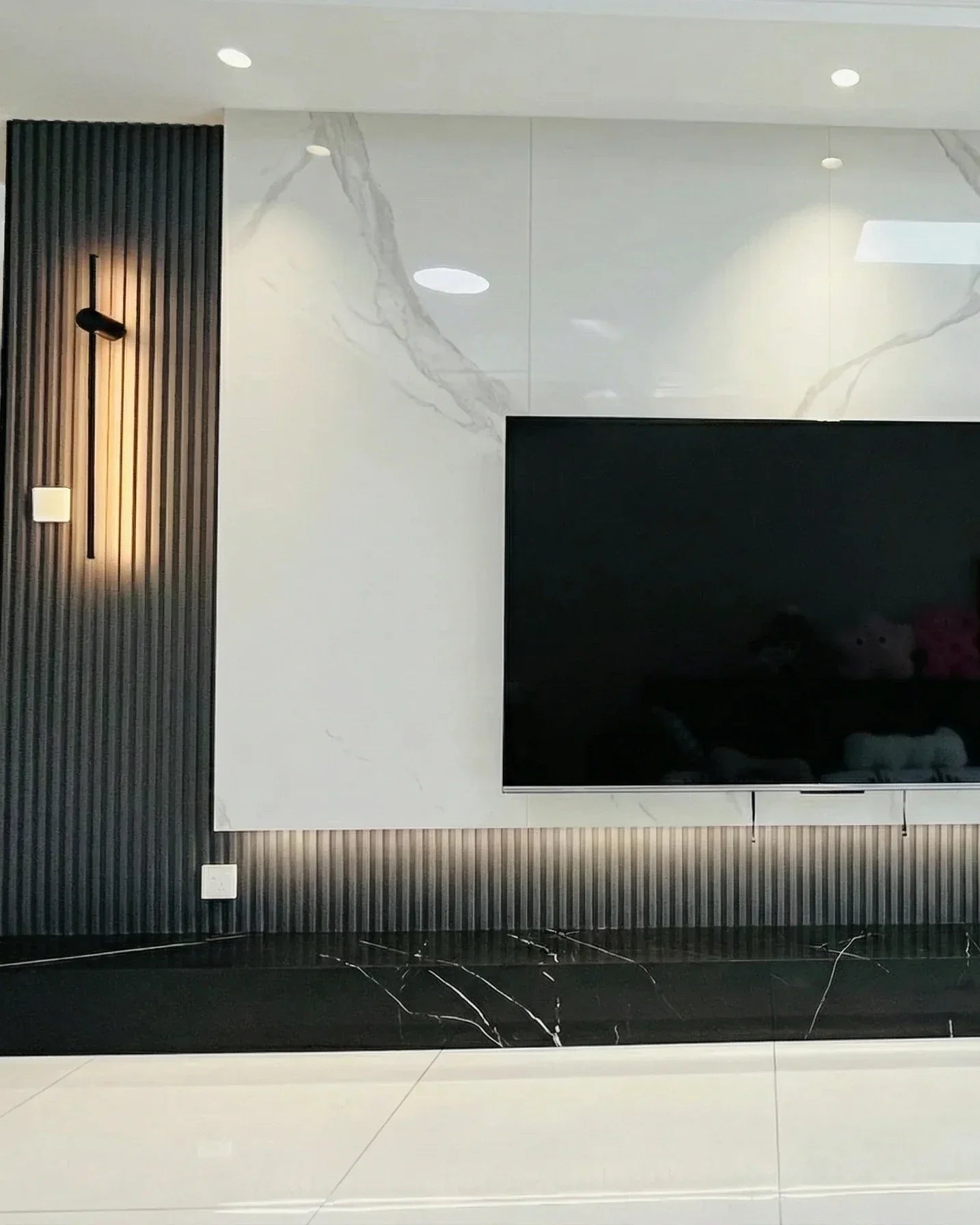 Antes y después: pared de TV con listones WPC y mármol blanco alto brillo en Málaga