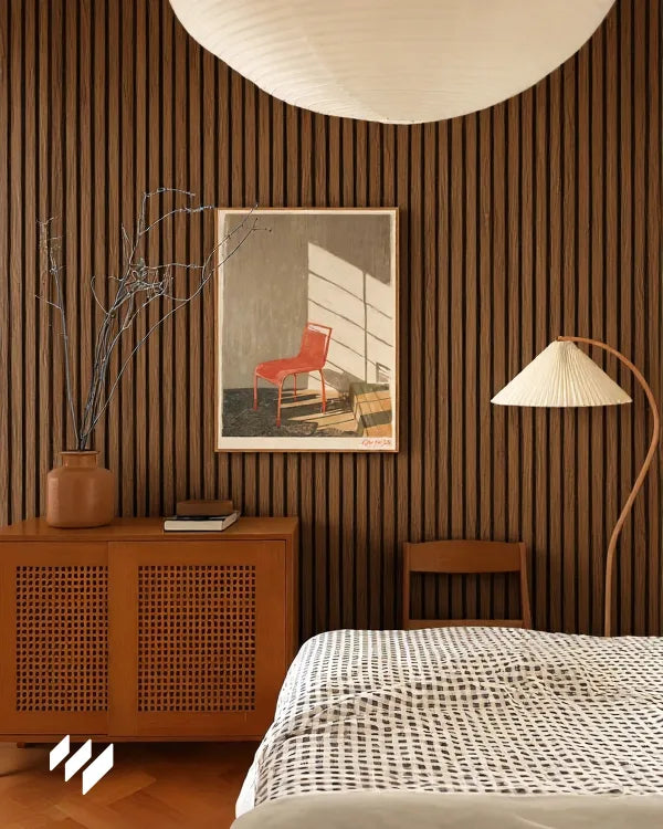  Revestimiento de Pared 3D Palillería Acústica en color Roble Ahumado de Revestimientos Pared instalado en un dormitorio acogedor con iluminación suave y arte contemporáneo.