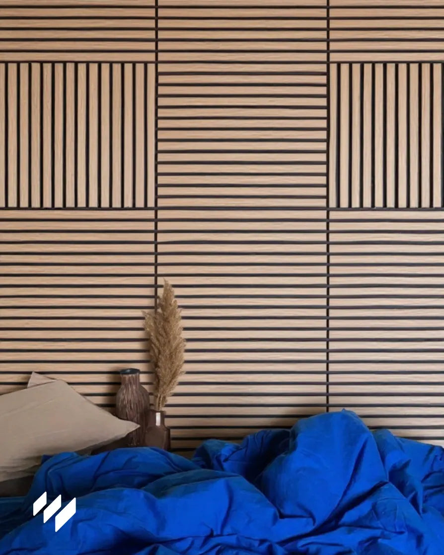 Cabecero de cama decorado con paneles acústicos autoadhesivos de listones en roble natural de 60x60cm, dispuestos en patrón geométrico para un acabado cálido y contemporáneo.