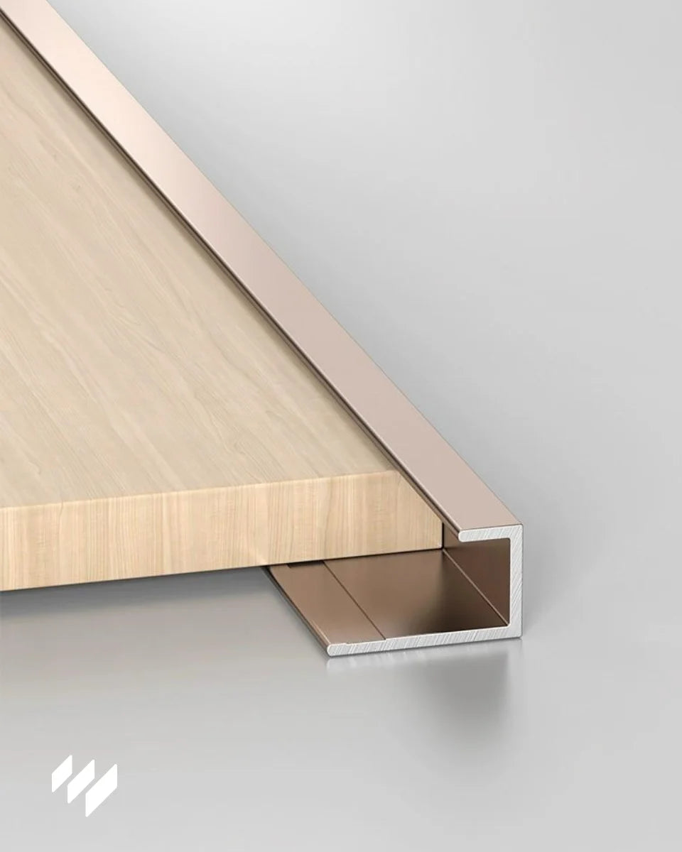 Perfil de remate en U de aluminio oro rosa brillante instalado en panel de madera de revestimientos pared