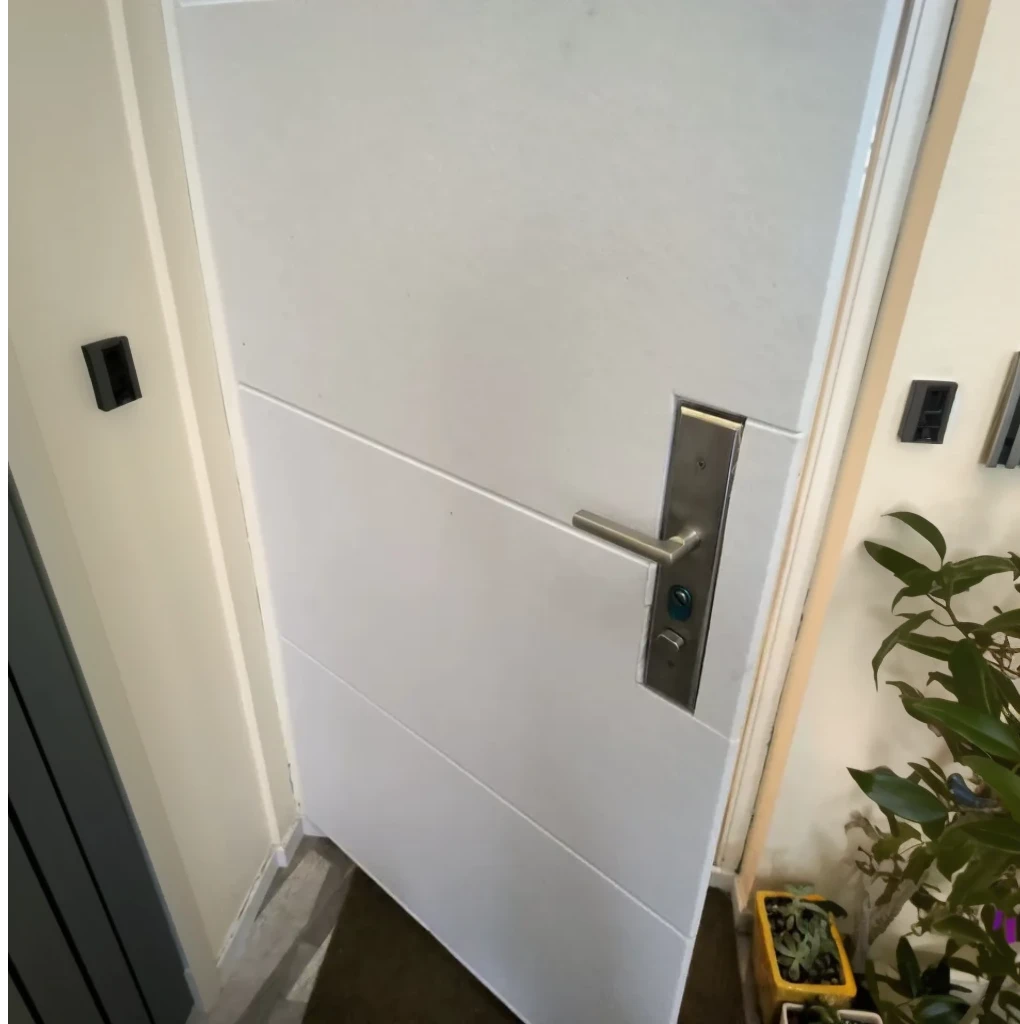 Puerta recubierta con espuma acústica autoadhesiva de poliéster blanca, mejorando la insonorización del hogar. Aunque aún se oyen ruidos, la sensación de cercanía con el ruido externo se reduce considerablemente. Instalación limpia y visualmente discreta.