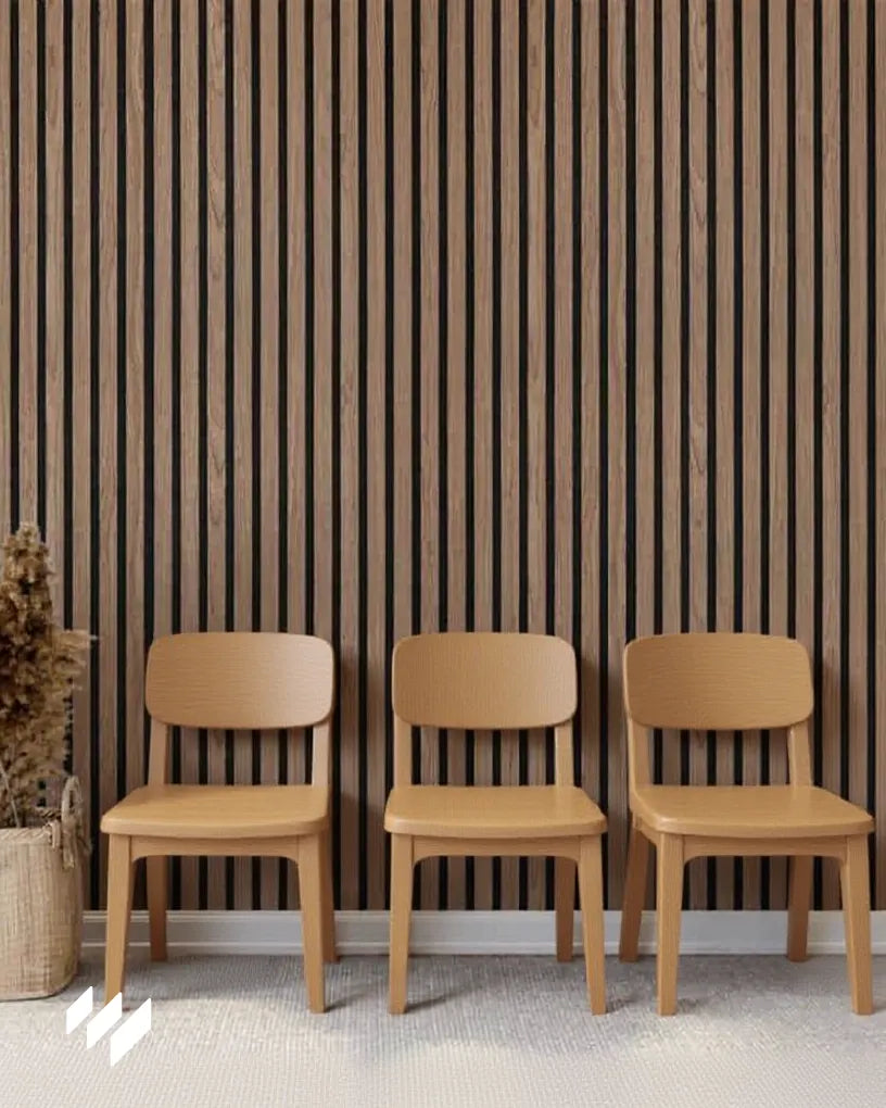 Instalación de panel acústico de listones Nogal Natural de Revestimientos Pared detrás de tres sillas de madera clara, ideal para espacios de recepción modernos y confortables.