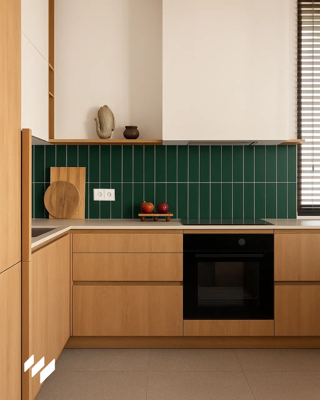 Cocina en L con muebles de madera clara, encimera beige y fondo de pared revestido con panel SPC imitación azulejo vertical verde oscuro mate.