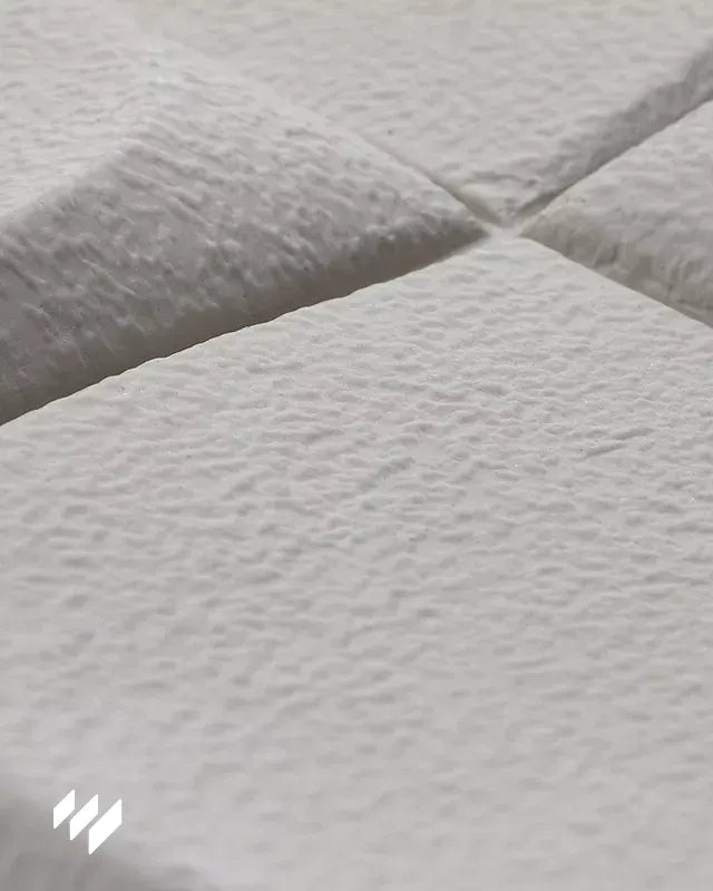 Detalle en primer plano del Panel decorativo 3D de PU efecto Almohadillado blanco de Revestimientos Pared, mostrando su textura acolchada en relieve para un diseño moderno.