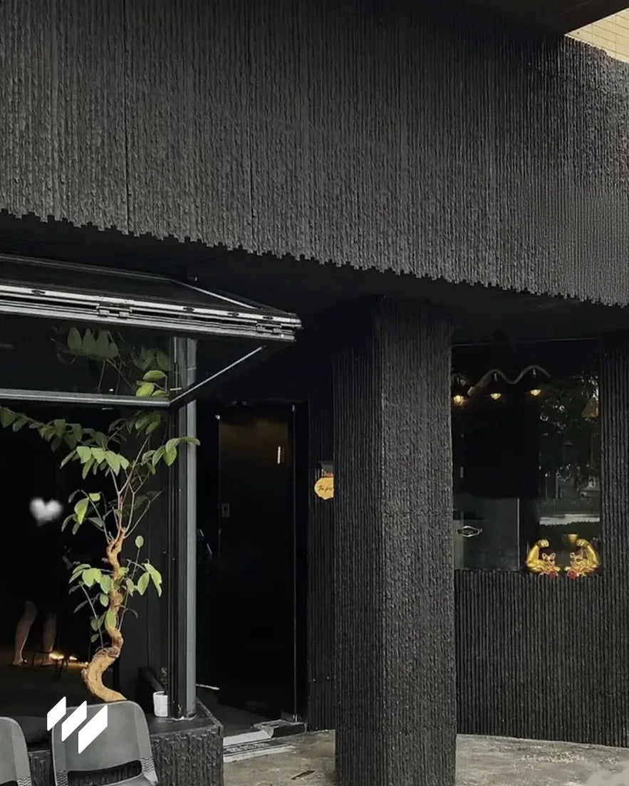 Fachada revestida con Revestimiento de pared efecto piedra acanalada negro de Revestimientos Pared, aportando carácter y estilo contemporáneo a exteriores.