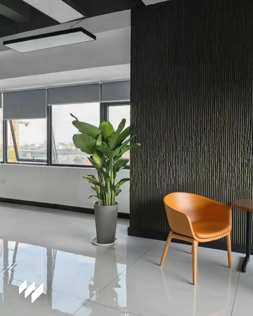 Pared interior decorada con Revestimiento de pared efecto piedra acanalada negro de Revestimientos Pared, creando un ambiente moderno y elegante para oficinas.