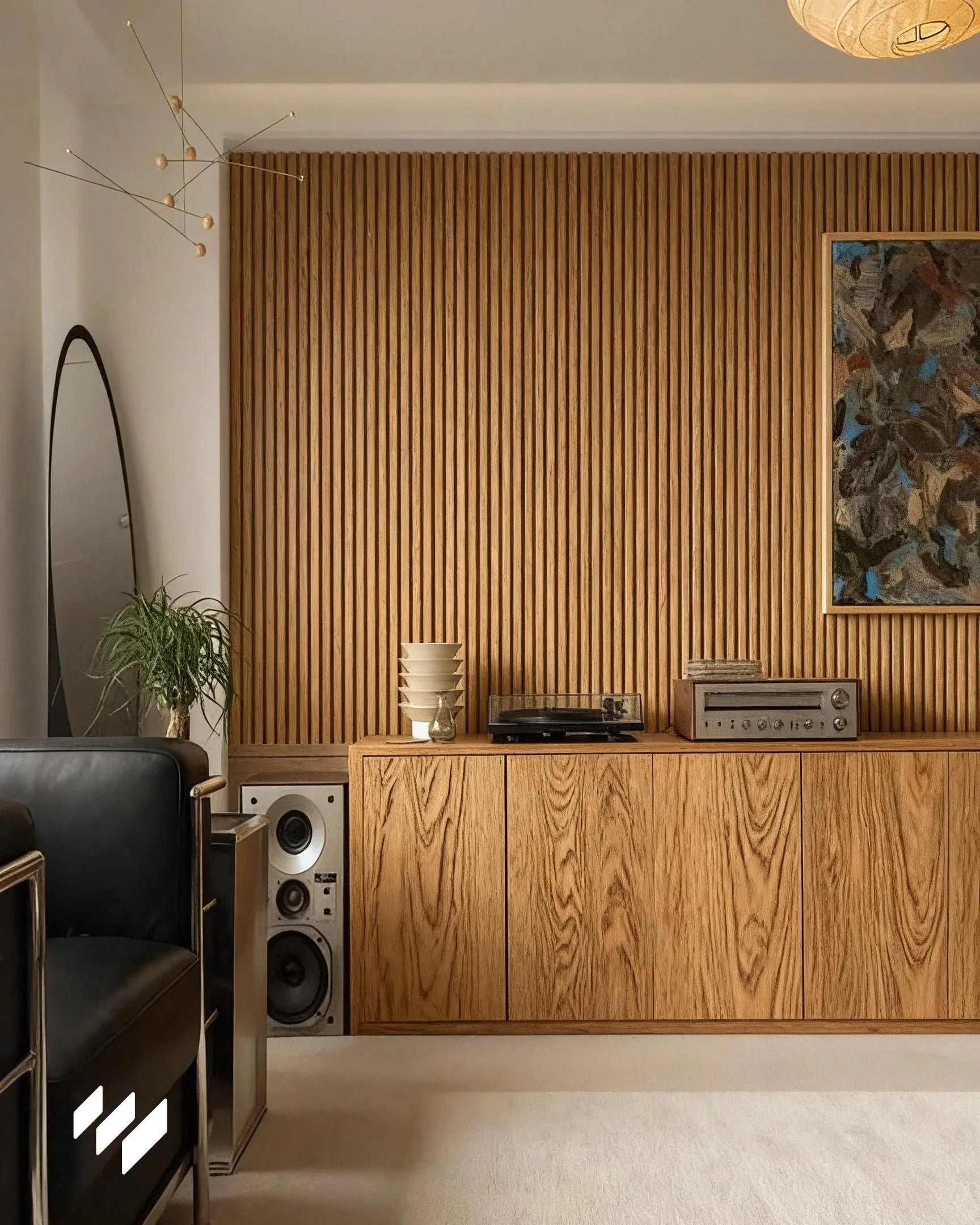 Pared decorada con listones WPC Roble Miel en un salón retro con mueble de roble y tocadiscos en Barcelona.